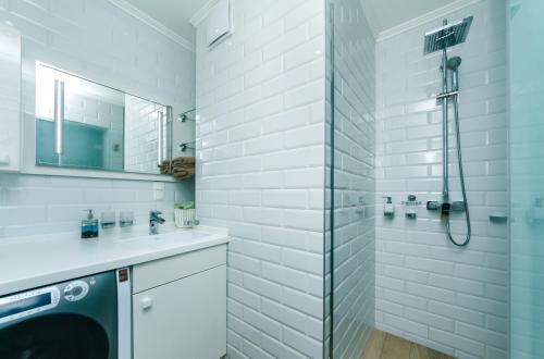 キーウにあるSmart apartmentの白いバスルーム(シャワー、洗濯機付)
