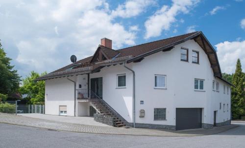 a white house with a staircase on the side of it at Ferienwohnungen Mildenberger in Birkenau