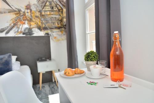 a table with a bottle and a plate of food at Hotel des Arts - Centre Cathédrale in Strasbourg