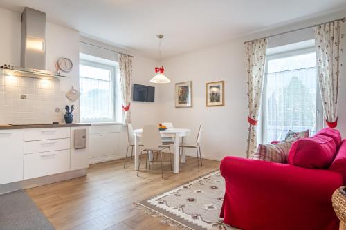 a living room with a red couch and a table at Holiday Apartments Val Moena in Cavalese