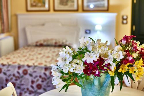 a vase of flowers sitting on a table in a bedroom at Albergo Trattoria Il Leone in Pomponesco