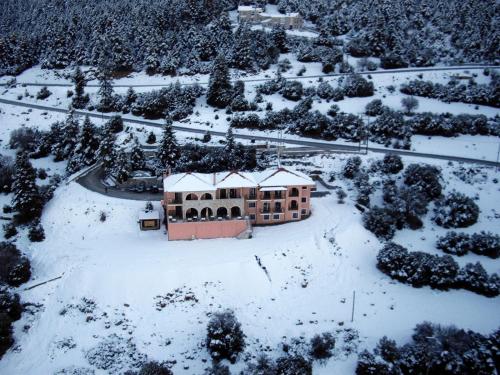 a house in the snow with snow on it at Vytina Mountain View Hotel in Vytina