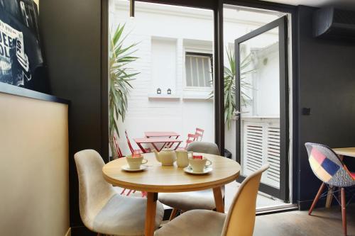 une salle à manger avec une table et des chaises dans l'établissement Hotel Auguste, à Paris
