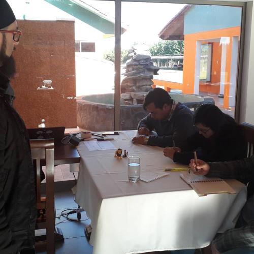 two people sitting at a table writing on paper at Willy's Country Club Cauquenes in De Cauquenes