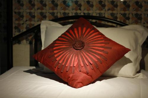 a red pillow sitting on top of a bed at First IN in Madgaon