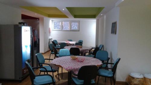 a room with four tables and chairs and a refrigerator at Pavia Ostello in Pavia