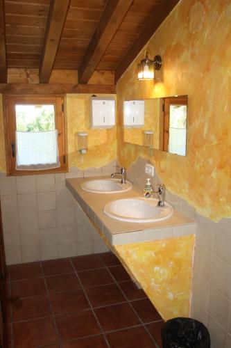 ein Badezimmer mit zwei Waschbecken und zwei Spiegeln in der Unterkunft El Escondite del Miera in San Roque de Ríomiera