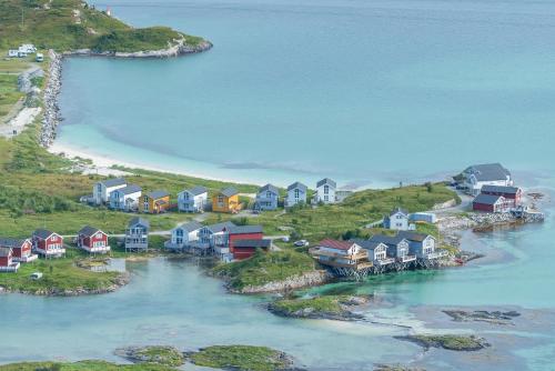 an aerial view of a village on a hill with a beach at Sommarøy Arctic Hotel Tromsø in Sommarøy