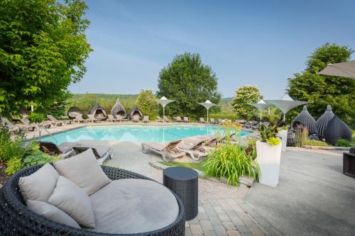 a swimming pool with a wicker chair next to at Estrimont in Magog-Orford