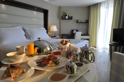 a hotel room with a tray of food on a bed at Ramada Plaza Antalya in Antalya