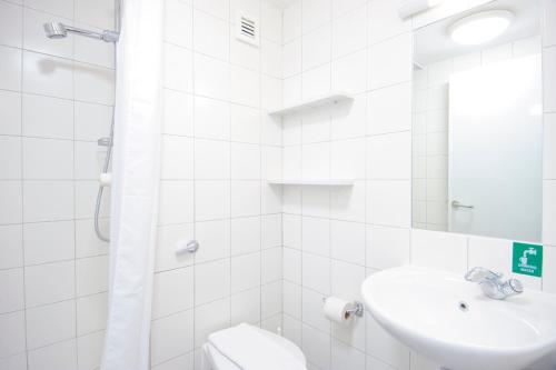 a white bathroom with a sink and a toilet at Venue Reading Accommodation in Reading