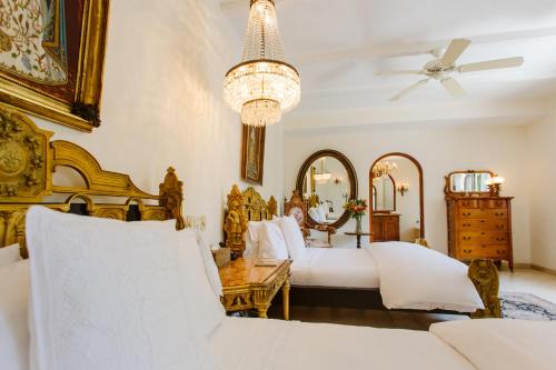 a bedroom with two beds and a chandelier at Hacienda San Angel in Puerto Vallarta