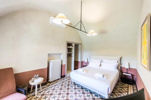 ein Schlafzimmer mit einem weißen Bett und einem Waschbecken in der Unterkunft La Bastide de Ganay in Aix-en-Provence
