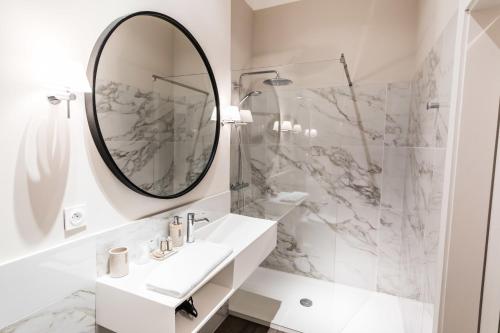 a white bathroom with a sink and a mirror at Bastide de Ganay - Saint Jérôme in Aix-en-Provence