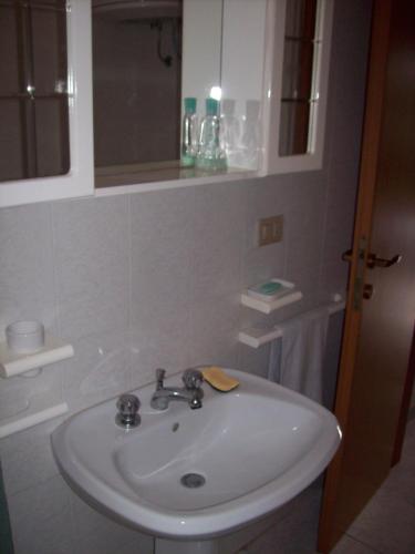 a bathroom with a white sink and a mirror at Villa del Palmeto in Badesi