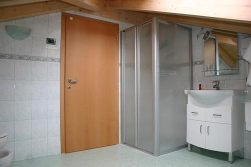 baño con ducha y puerta de madera en Agritur Due Valli, en Livo