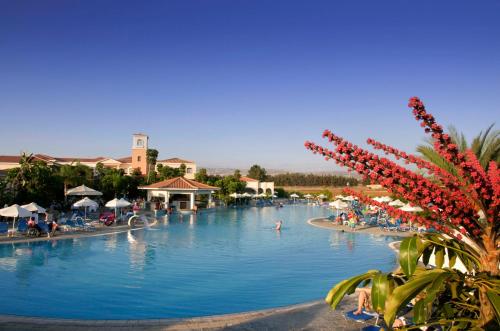 a pool at a resort with people swimming in it at Avanti Holiday Village in Paphos