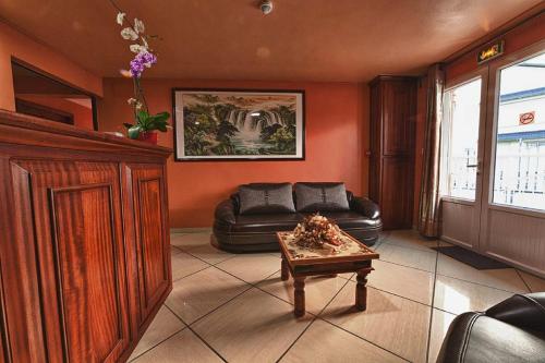 a living room with a leather couch and a table at Otroiza Hotel in Cilaos