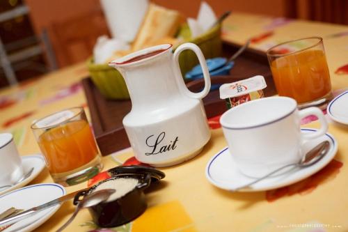 a table with cups and saucers and a tea pot at Otroiza Hotel in Cilaos