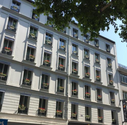 un gran edificio blanco con ventanas y macetas de flores en Hôtel Lumières Montmartre Paris, en París