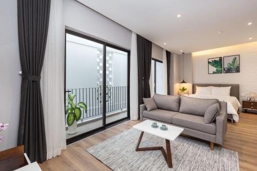 una camera con letto, divano e tavolo di Cozrum Homes - Premier Residence ad Ho Chi Minh
