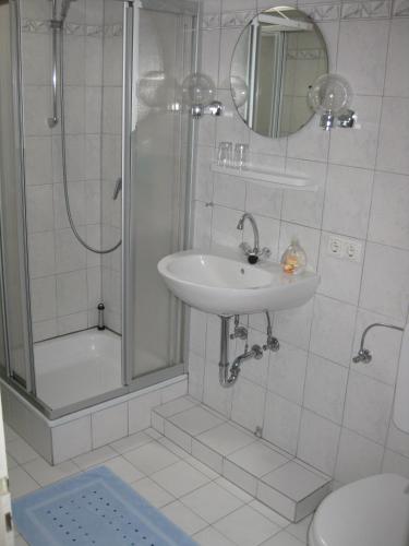 a bathroom with a sink and a shower and a toilet at Ferienwohnung Ulrike Narjes in Volkwardingen