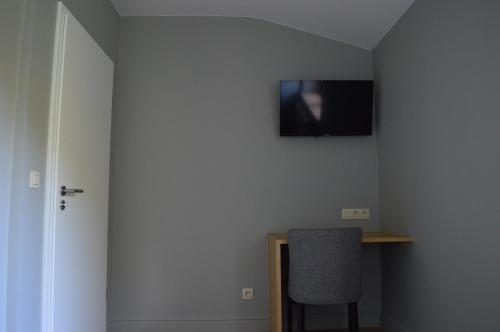 a room with a desk and a television on a wall at Hotel La Heid des Pairs in Spa