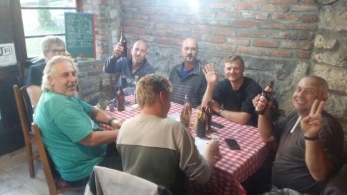 a group of people sitting around a table drinking beer at Kanjon Uvac in Sjenica