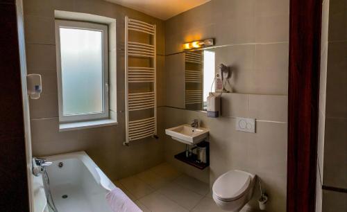 ハイドゥソボスローにあるPlage Apartmanのバスルーム(バスタブ、洗面台、トイレ付)