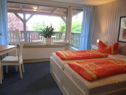 a bedroom with a bed and a table and a window at Gästezimmer Göring in Gamstädt