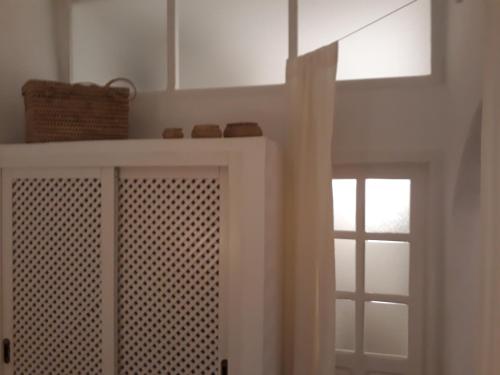 a white cabinet with a window in a room at Dar es Salam-Baja in Asilah