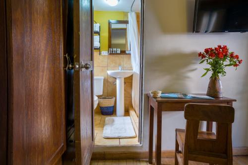 a small bathroom with a sink and a toilet at Pisac Inn in Pisac