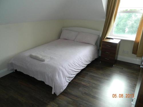 a small bedroom with a bed and a night stand at Circle Guest House Bed Only in Southampton