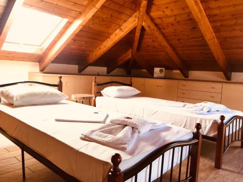 two beds in a room with wooden ceilings at Villa Lydia in Nydri