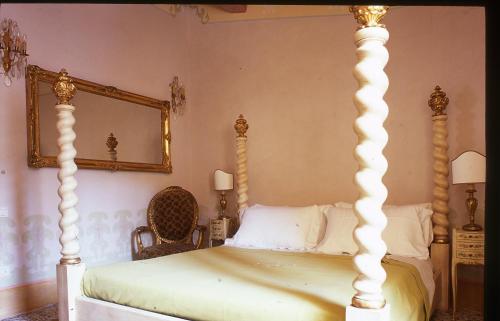 a bedroom with a four poster bed and a mirror at Locanda Pietrasantese B&B in Pietrasanta