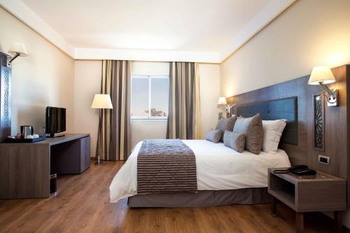 a hotel room with a bed and a television at Sky Casa Airport in Nouaseur
