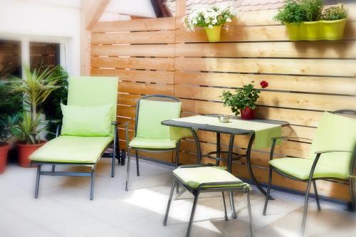 a table and chairs on a patio with a wooden wall at Pension Amthof in Oberderdingen