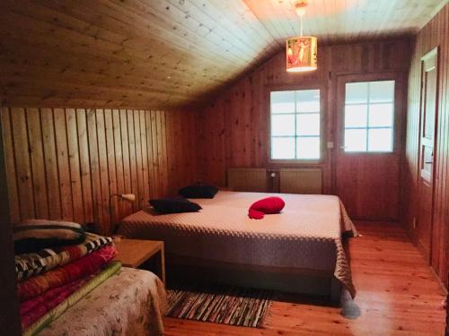 a bedroom with two beds in a wooden room at Unien Koti Cottage in Mattila