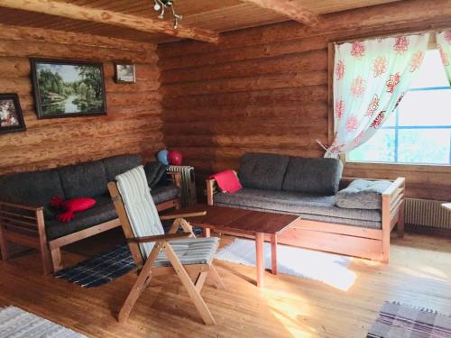 a living room with a couch and a table at Unien Koti Cottage in Mattila