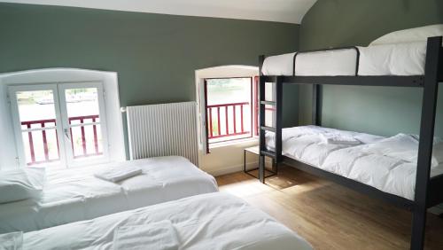a bedroom with two bunk beds and two windows at MARA RIVIERE Gîte d'étape sur la Vélo Francette in La Jaille-Yvon
