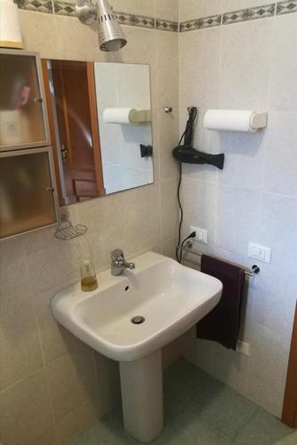 bagno con lavandino bianco e specchio di ROMA M3 JONIO Double ROOM with BATHROOM a Roma