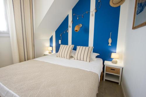 een slaapkamer met een wit bed en een blauwe muur bij Casa Cosy Le Pouliguen in Le Pouliguen