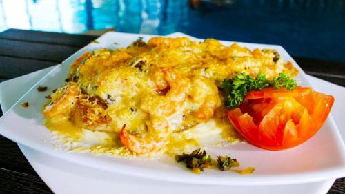 a plate of food with a tomato on a table at Hotel Campestre El Cisne in Barranquilla