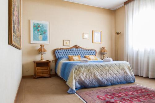 een slaapkamer met een blauw bed en een raam bij APPARTAMENTO AMPIO E INDIPENDENTE Con VISTA GIARDINO in Paderno dʼAdda