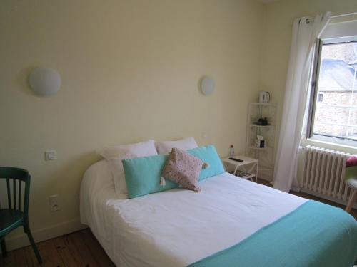 a bedroom with a bed with two pillows on it at Le Camélia in Ruillé-Froid-Fonds