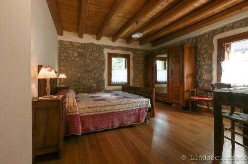 um quarto com uma cama num quarto com pisos em madeira em Il Capriolo Felice - Agriturismo em Lastebasse