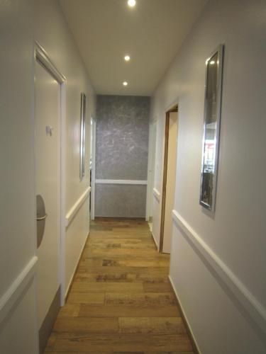 a hallway with wooden floors and white walls at Le Camélia in Ruillé-Froid-Fonds