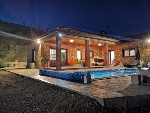 a house with a swimming pool at night at Kalamospito Holiday House in Kalokhorio