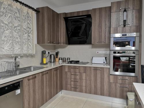 a kitchen with wooden cabinets and stainless steel appliances at Kalamospito Holiday House in Kalokhorio