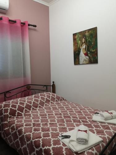 a bedroom with a bed and a painting on the wall at Kalamospito Holiday House in Kalokhorio
